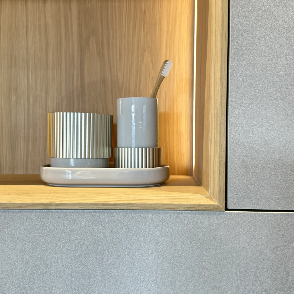 Detail of a wooden niche in a DecoLegno cabinet with ribbed ceramic bathroom accessories, reflecting expertise in luxury bathroom designs.